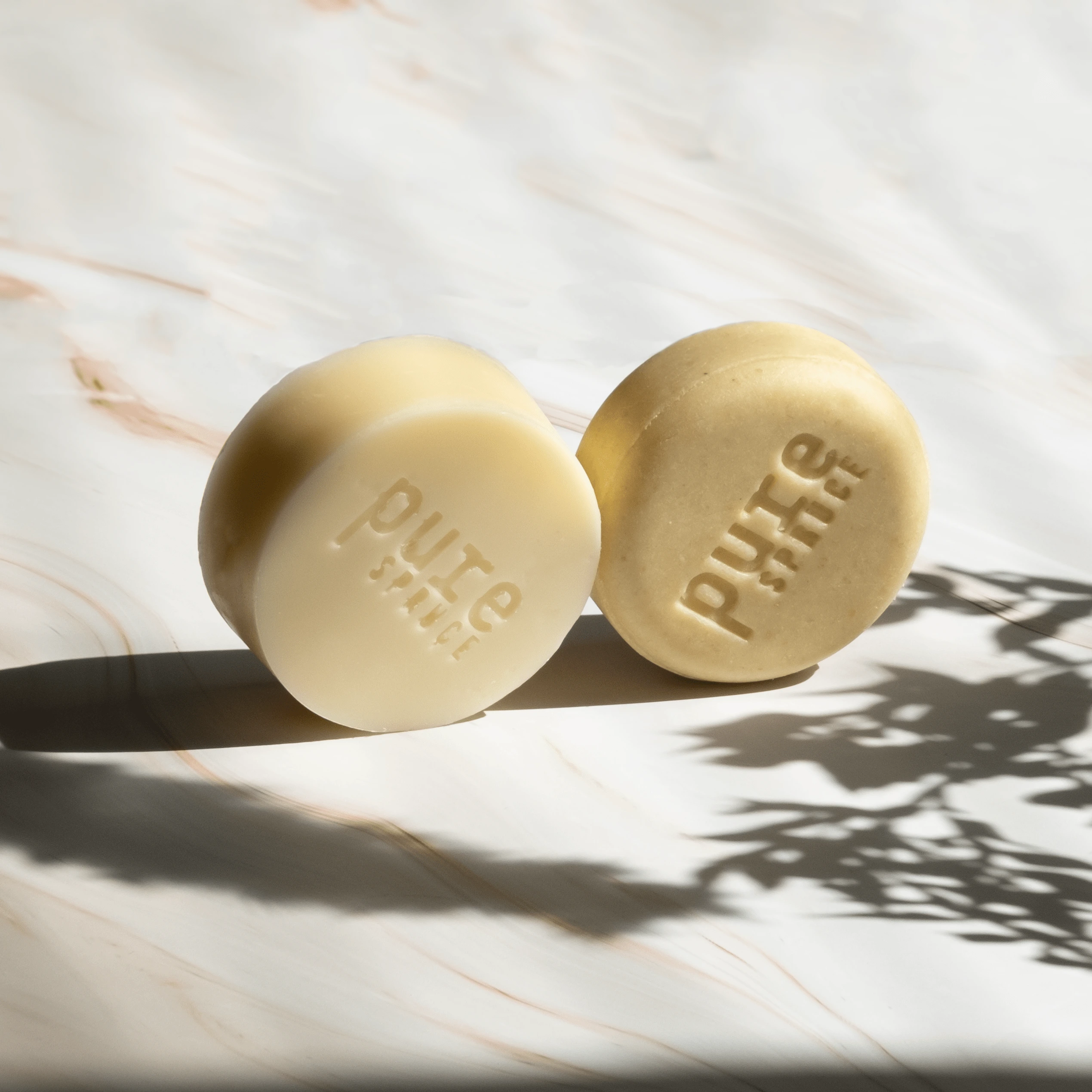 Two round shampoo natural bars on surface, Purespruce